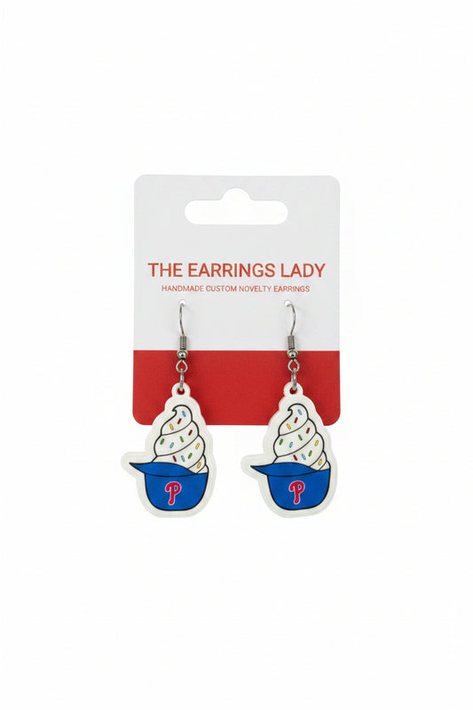 Pair of ice cream cone earrings with a branded card on a carpeted surface