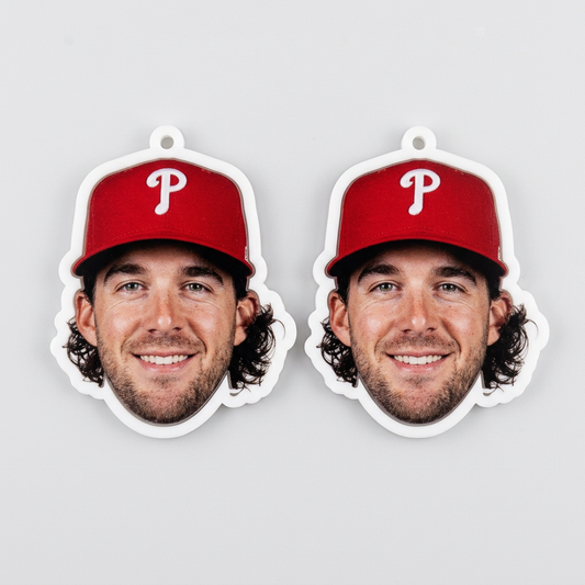 Two paper cutouts of a man wearing a red baseball cap with a 'P' logo on a gray background.