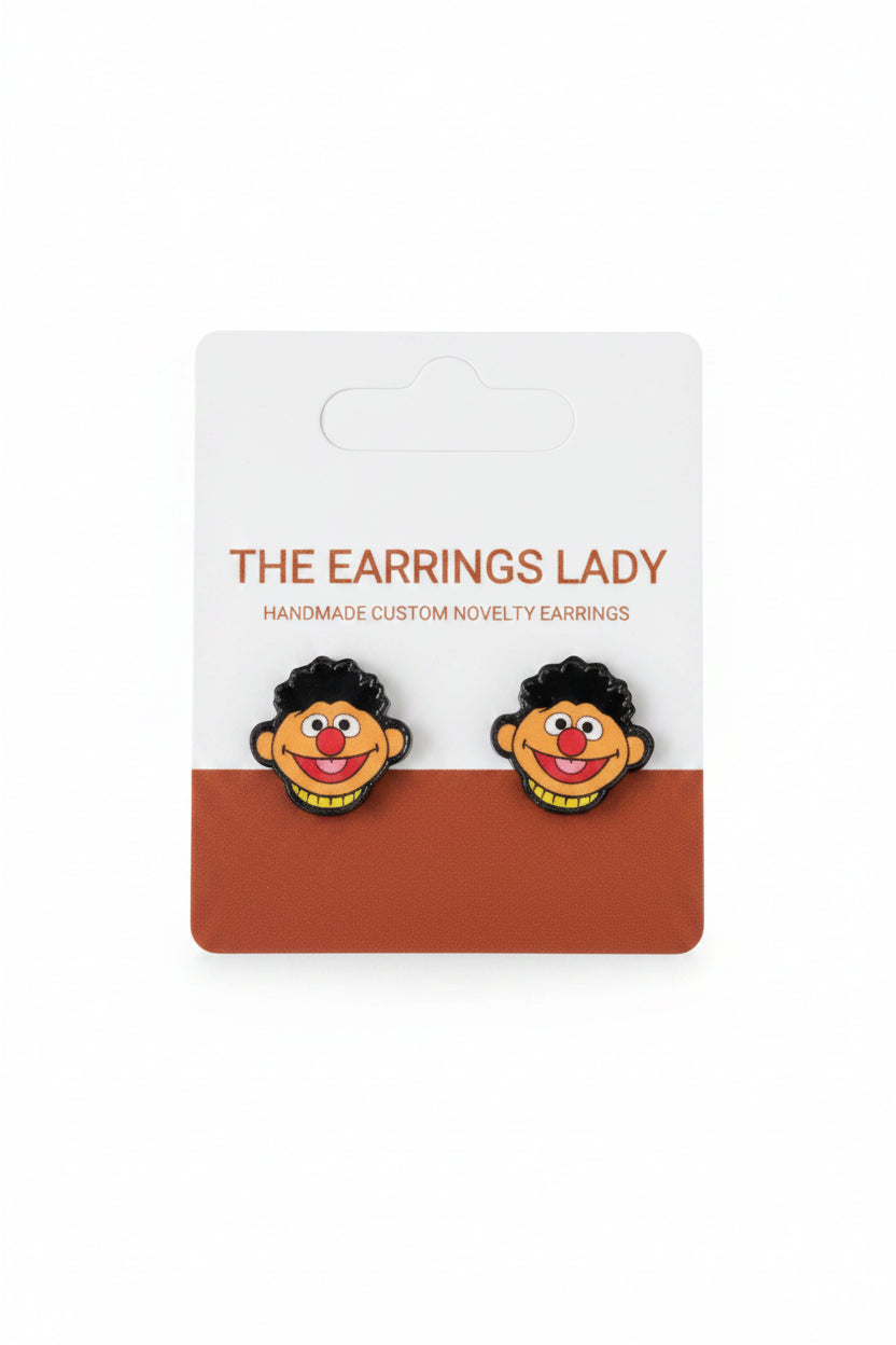 Pair of novelty earrings with a cartoon character design on a branded card.