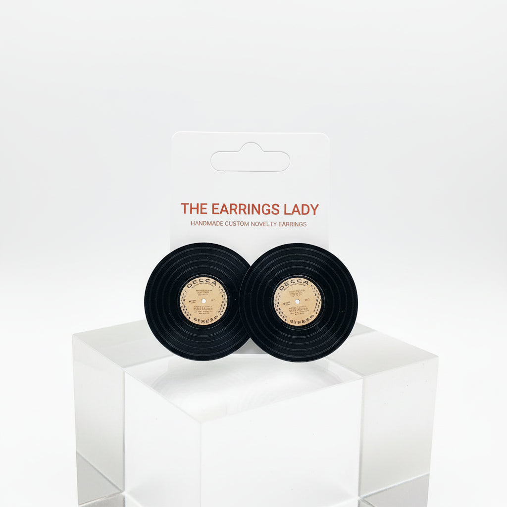 Black earrings in a box with 'The Earrings Lady' label on a white surface.
