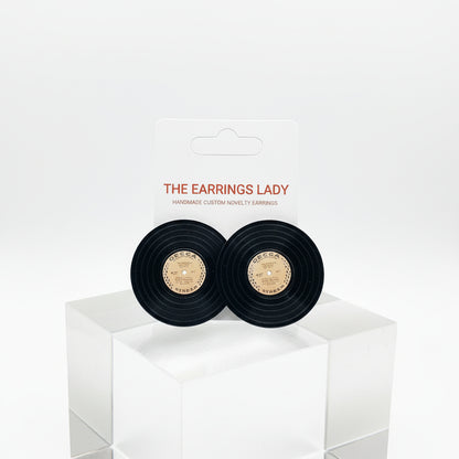 Black earrings in a box with 'The Earrings Lady' label on a white surface.