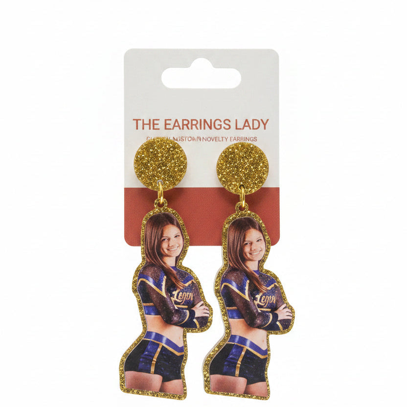 Earrings with a packaging card featuring a person in a uniform, held by a hand.