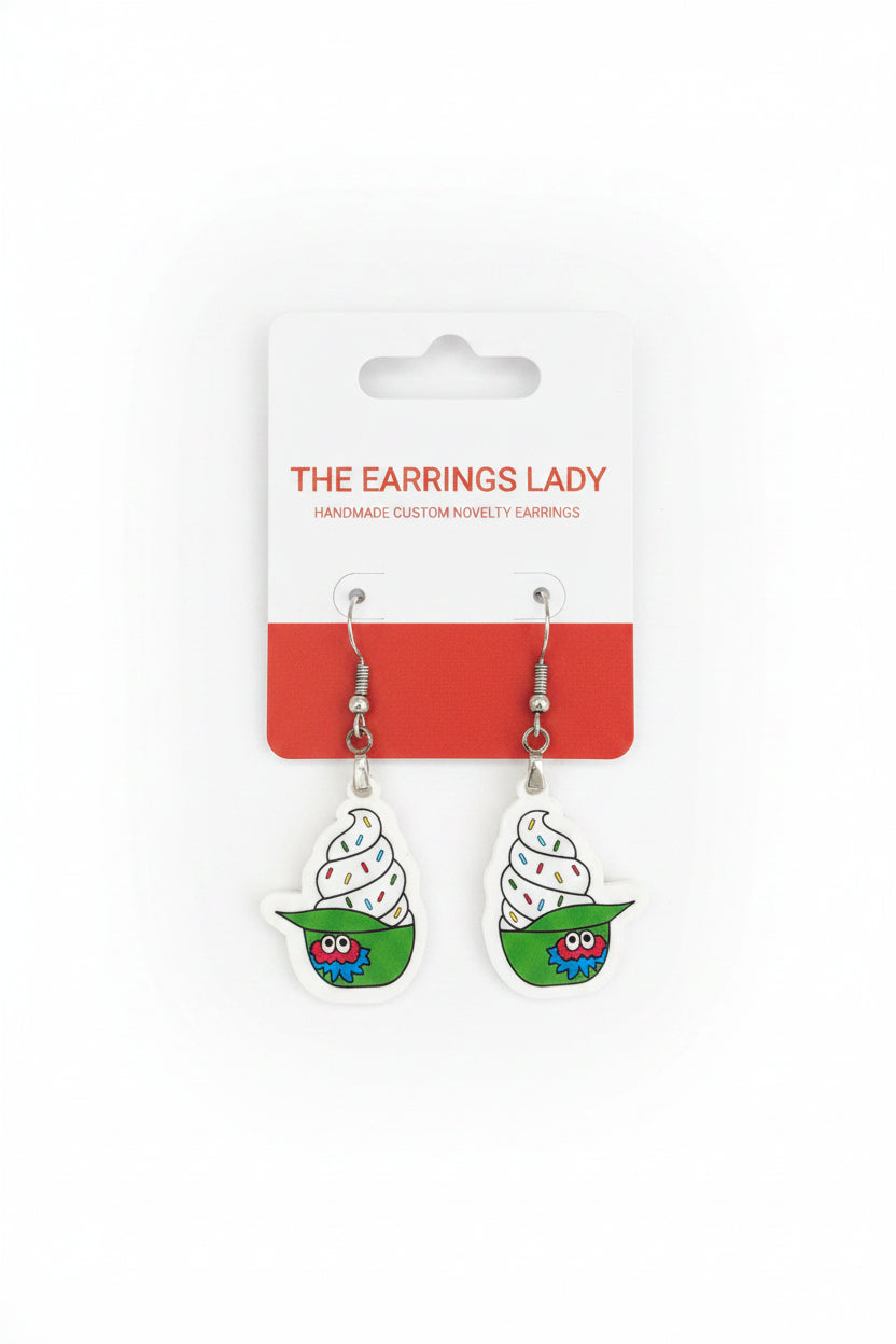 Pair of earrings on a card labeled 'The Earring Lady' on a carpeted floor.
