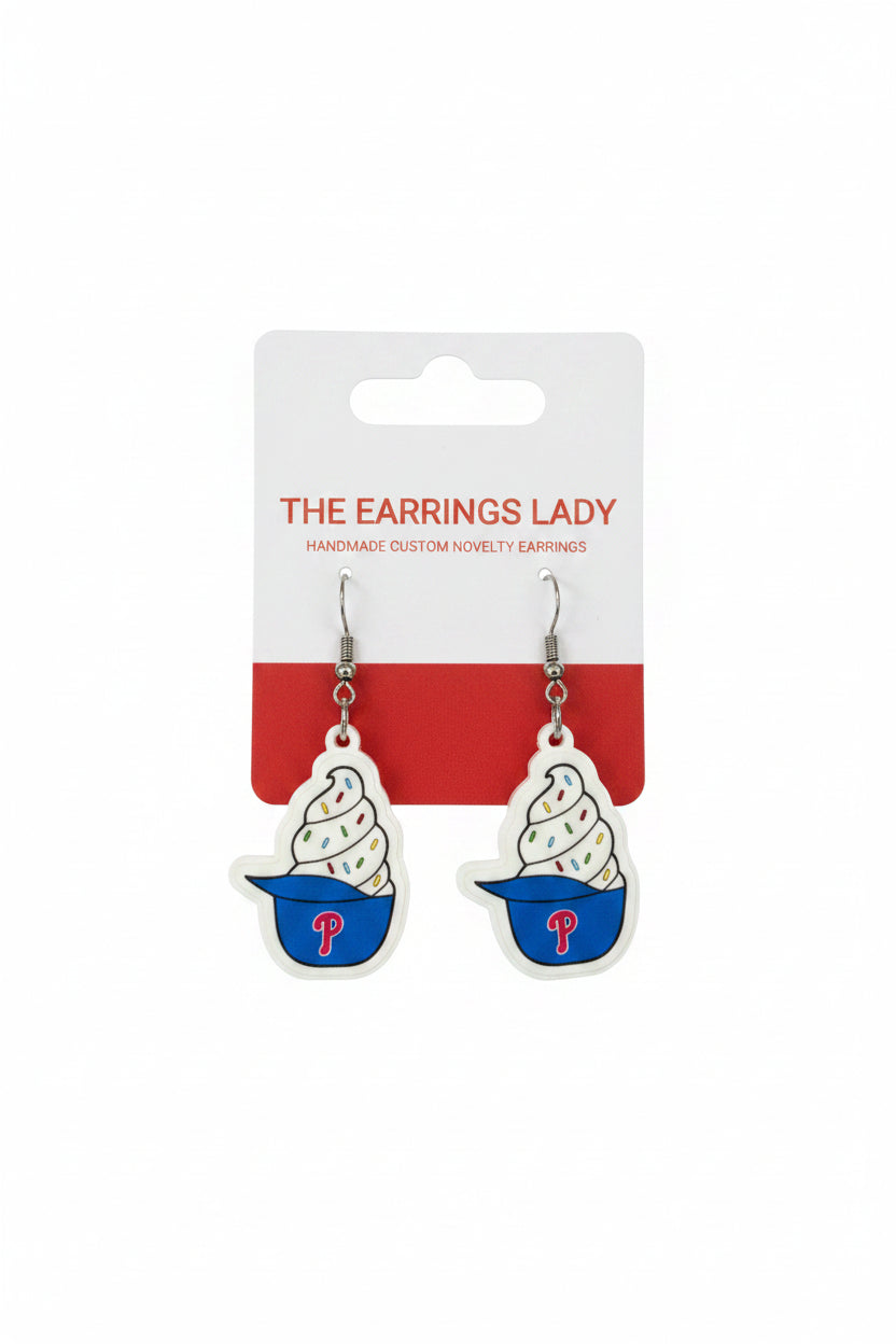 Pair of ice cream cone earrings with a branded card on a carpeted surface