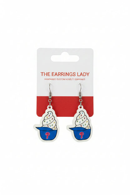 Pair of ice cream cone earrings with a branded card on a carpeted surface