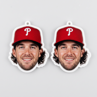 Two paper cutouts of a man wearing a red baseball cap with a 'P' logo on a gray background.