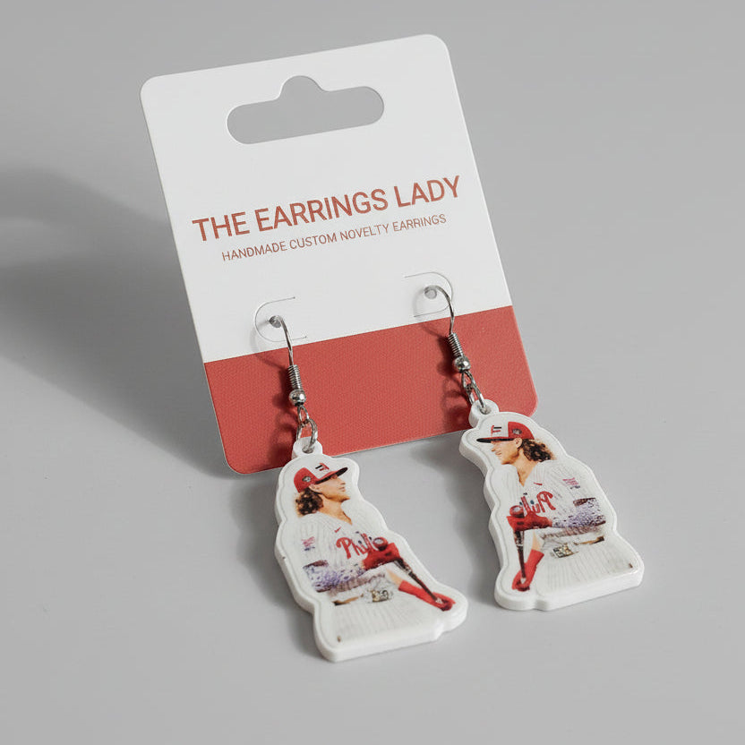 Earrings of a baseball player on a 'The Earrings Lady' card against a gray background