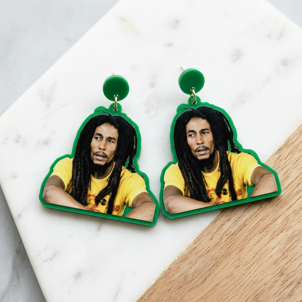 Earrings with a portrait of a person in a yellow shirt on a marble surface