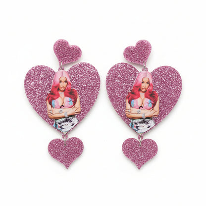 Heart-shaped earrings with a Cardi Bwith pink hair 