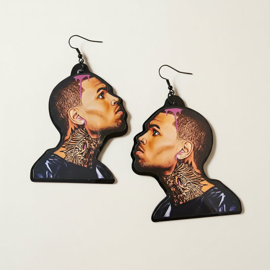 Earrings with a design of a chris brown's face and tattoos on a plain background