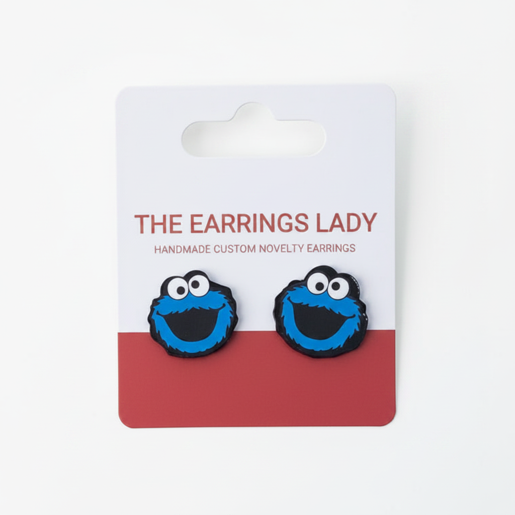 Cookie Monster earrings on a branded card with 'The Earrings Lady' branding.
