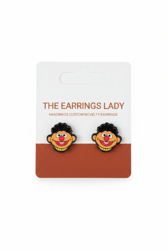 Pair of novelty earrings with a cartoon character design on a branded card.