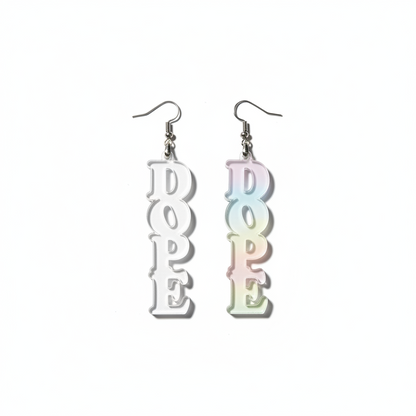 Clear 'DOPE' earrings held by a hand with a neutral background