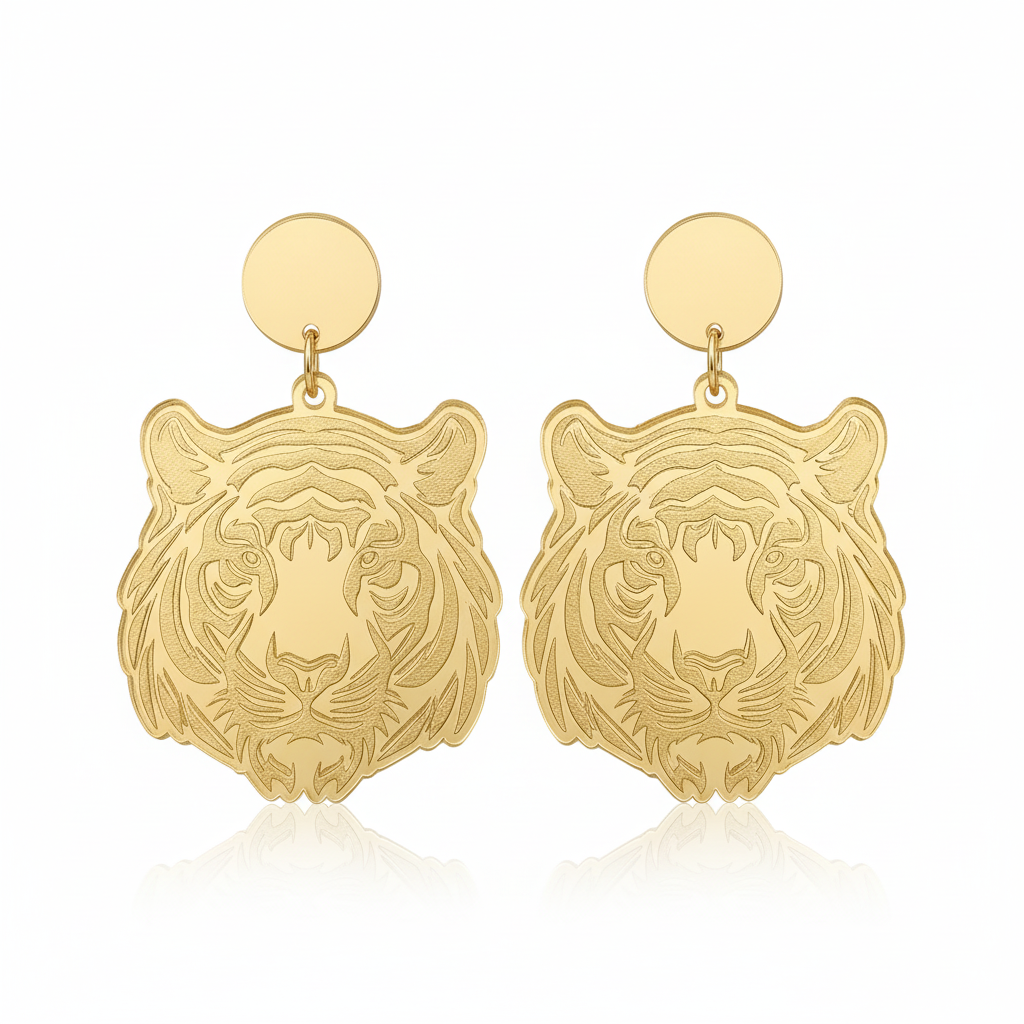 Gold tiger head earrings on a beige background