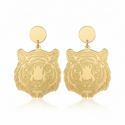 Gold tiger head earrings on a beige background