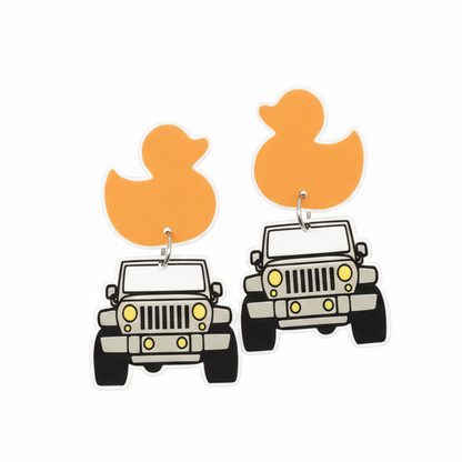Pair of earrings with duck and jeep designs on a brown card, held by a hand.