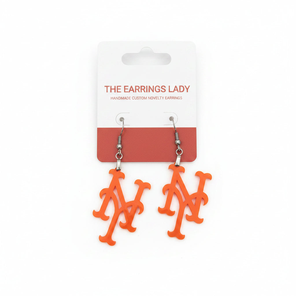 Orange novelty dangle earrings shaped like the New York Mets logo, displayed on a white and red backing card labeled 'THE EARRINGS LADY'.