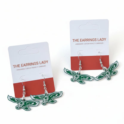 Green bird-shaped earrings on 'The Earrings Lady' branded cards against a brown background