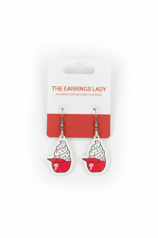 Ice cream cone-shaped earrings on a 'The Earrings Lady' branded card, displayed on a carpeted surface.