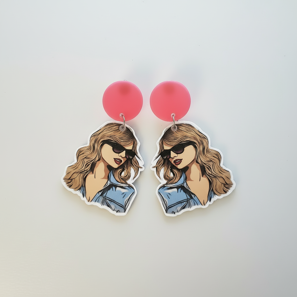 Earrings with cartoon-style illustration of a woman wearing sunglasses and a denim jacket on a light gray Taylor Swift inspired pop star portrait earrings.background.