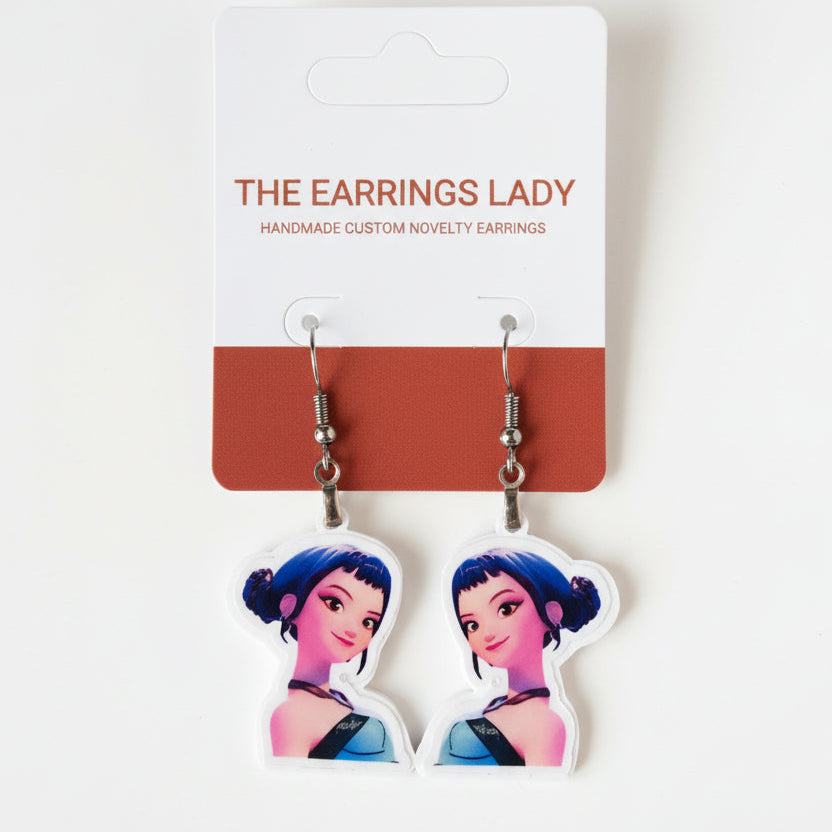 Earrings with character design on a branded card against a gray background
